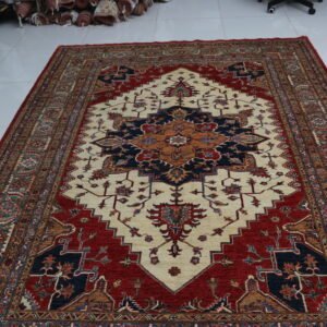 Handmade wool and cotton area rug or runner with traditional geometric Kazak pattern displayed on floor