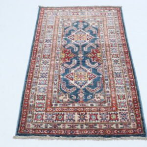 Handmade wool and cotton area rug or runner with traditional geometric Kazak pattern displayed on floor