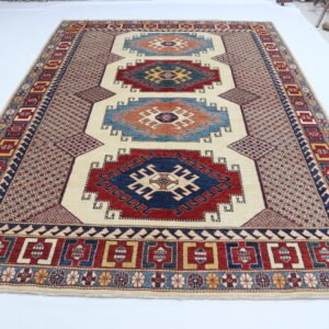 Handmade wool and cotton area rug or runner with traditional geometric Kazak pattern displayed on floor