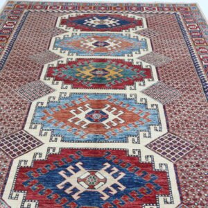 Handmade wool and cotton area rug or runner with traditional geometric Kazak pattern displayed on floor