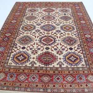 Handmade wool and cotton area rug or runner with traditional geometric Kazak pattern displayed on floor