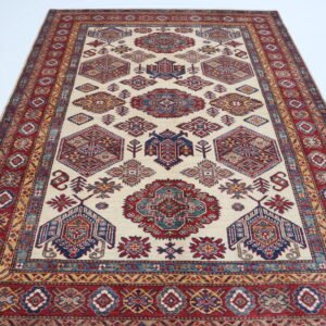 Handmade wool and cotton area rug or runner with traditional geometric Kazak pattern displayed on floor