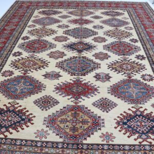 Handmade wool and cotton area rug or runner with traditional geometric Kazak pattern displayed on floor