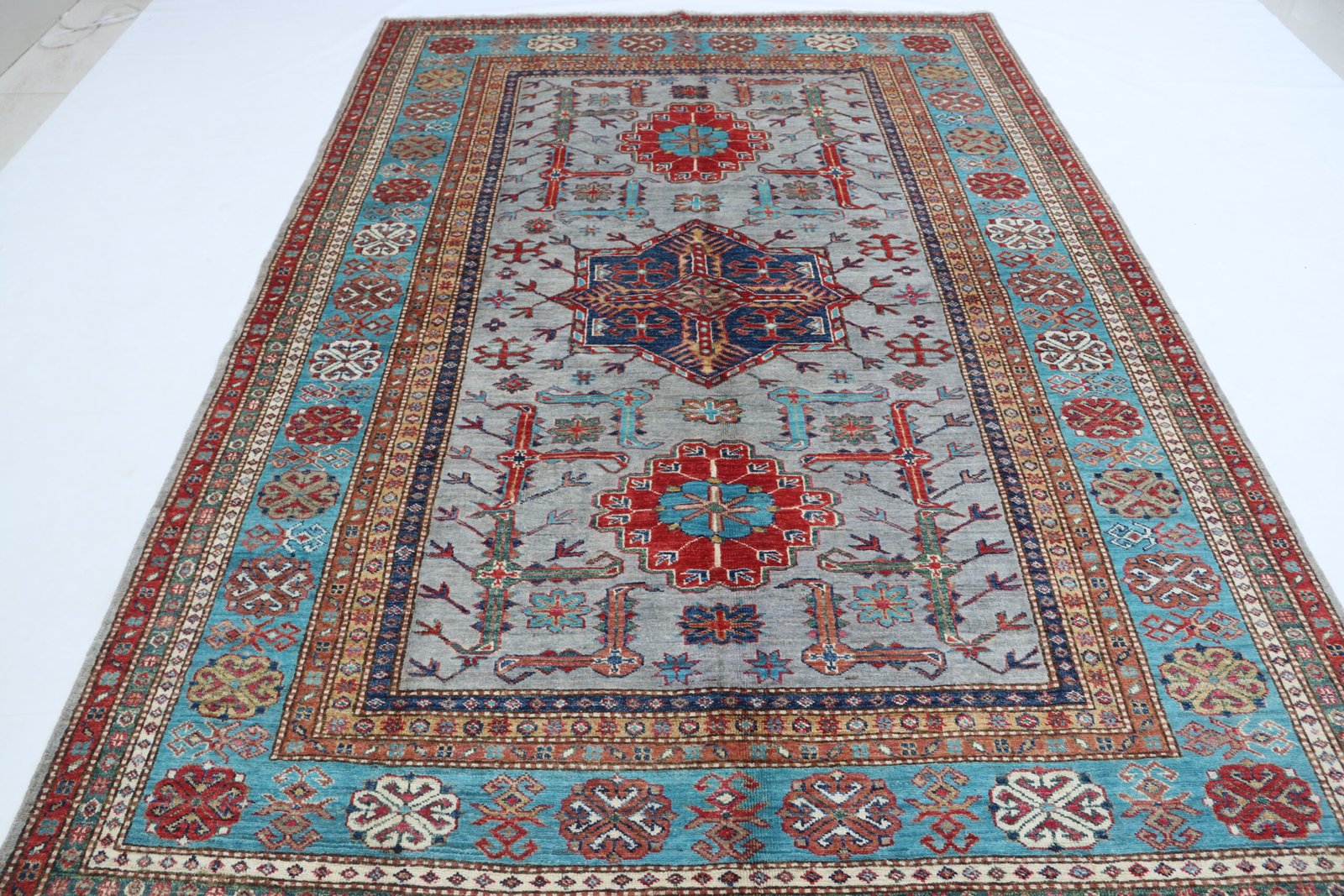 img 5176 Handmade wool and cotton area rug or runner with traditional geometric Kazak pattern displayed on floor
