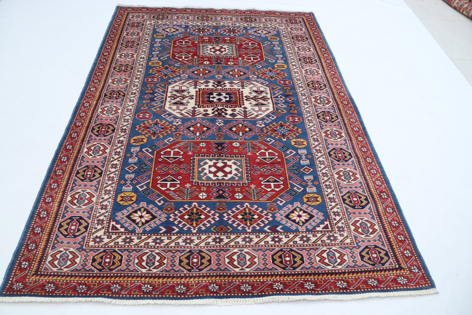 img 5210 Handmade wool and cotton area rug or runner with traditional geometric Kazak pattern displayed on floor
