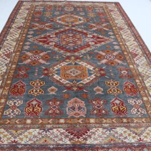 Handmade wool and cotton area rug or runner with traditional geometric Kazak pattern displayed on floor