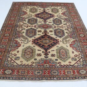 Handmade wool and cotton area rug or runner with traditional geometric Kazak pattern displayed on floor