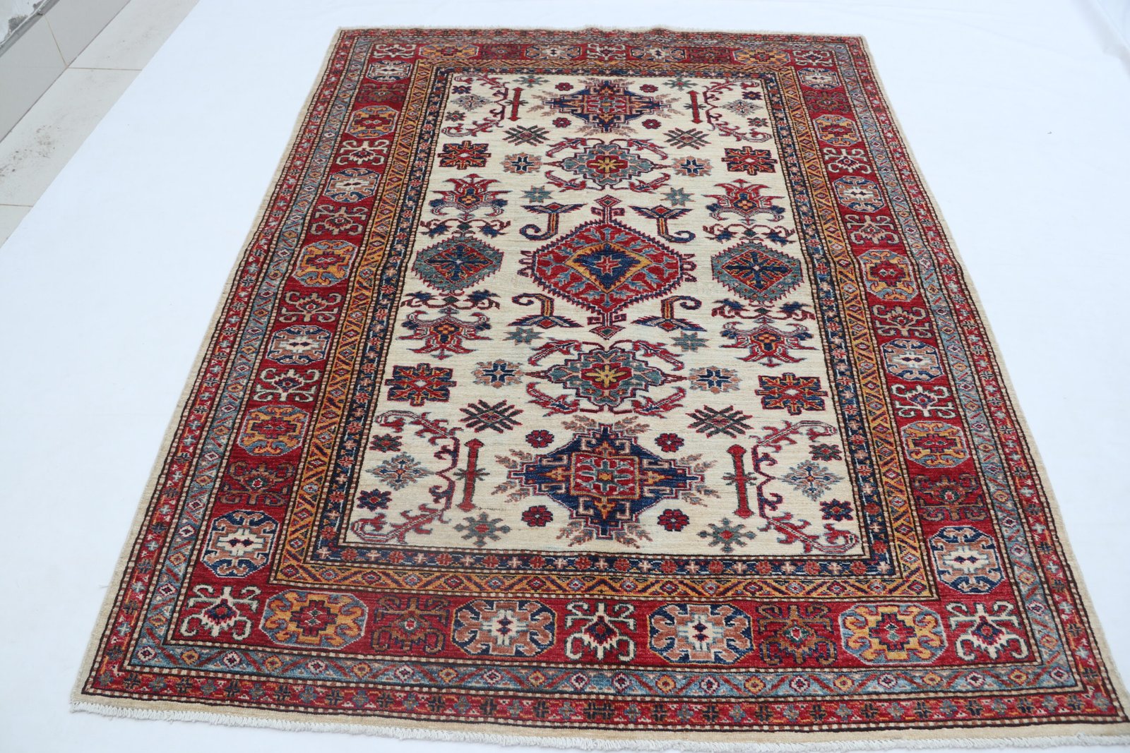img 5434 Handmade wool and cotton area rug or runner with traditional geometric Kazak pattern displayed on floor