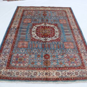 Handmade wool and cotton area rug or runner with traditional geometric Kazak pattern displayed on floor