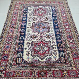 Handmade wool and cotton area rug or runner with traditional geometric Kazak pattern displayed on floor3.16.21 pm (2)