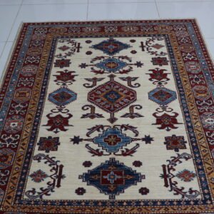 Handmade wool and cotton area rug or runner with traditional geometric Kazak pattern displayed on floor