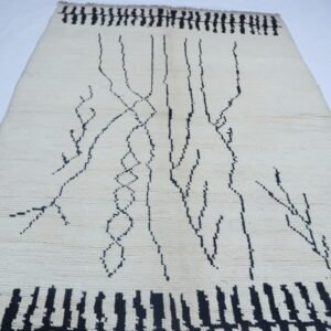 Handmade wool and cotton area rug or runner with repeated geometric Morocan pattern displayed on floor