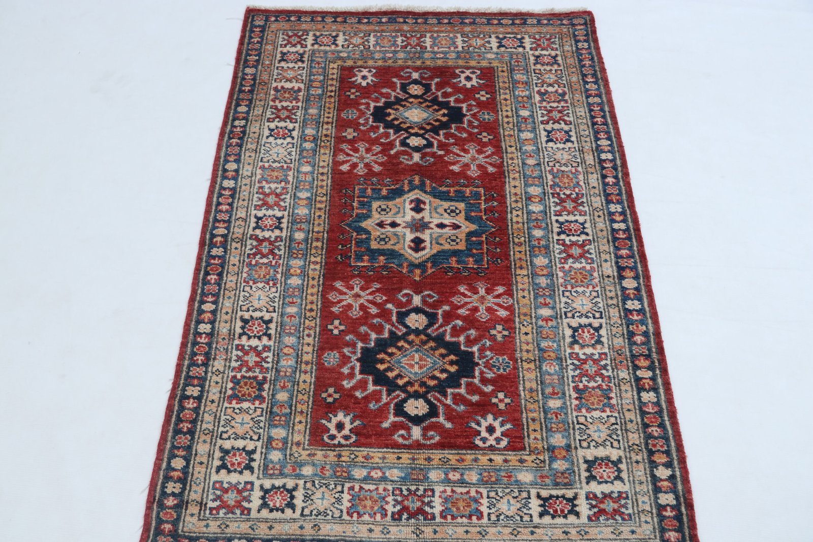 img 4849 Handmade wool and cotton area rug or runner with traditional geometric Kazak pattern displayed on floor