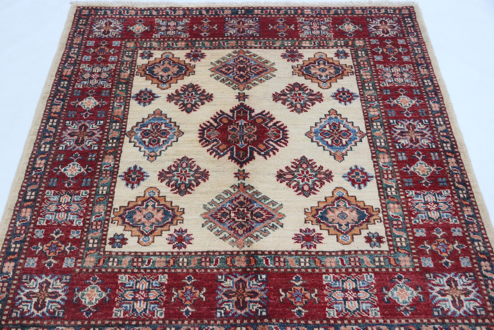 img 4906 Handmade wool and cotton area rug or runner with traditional geometric Kazak pattern displayed on floor