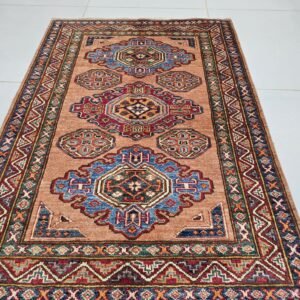 Handmade wool and cotton area rug or runner with traditional geometric Kazak pattern displayed on floor