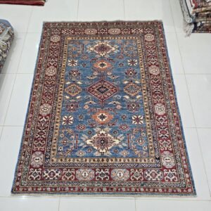 Handmade wool and cotton area rug or runner with traditional geometric Kazak pattern displayed on floor