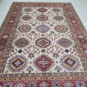 Handmade wool and cotton area rug or runner with traditional geometric Kazak pattern displayed on floor