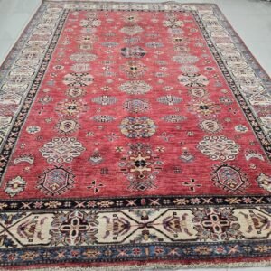 Handmade wool and cotton area rug or runner with traditional geometric Kazak pattern displayed on floor