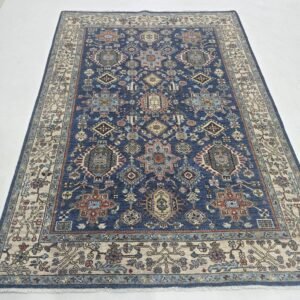 Handmade wool and cotton area rug or runner with classic floral Tribal pattern displayed on floor